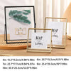 A set of modern metal and acrylic photo frames in gold and black finishes displayed on a wooden surface.