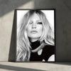 Black and white portrait of a woman with long blonde hair wearing a black turtleneck and a silver necklace