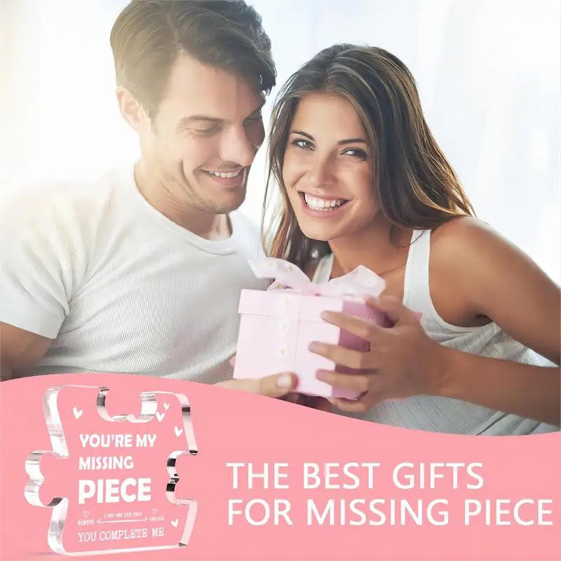 Un couple souriant présente une boîte cadeau rose à la caméra.