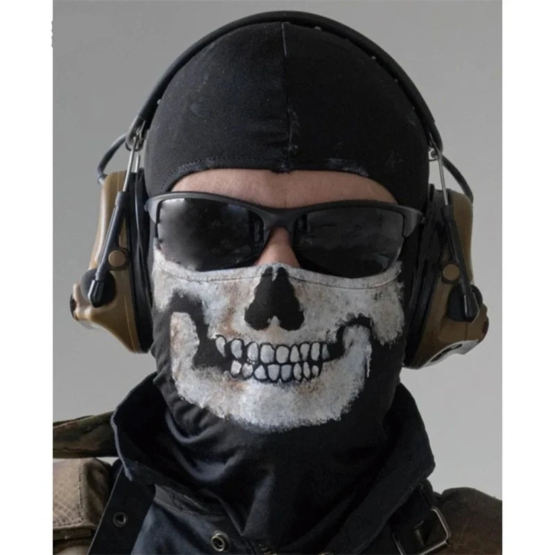 A person wearing a black hood and sunglasses with a white skull pattern face mask.