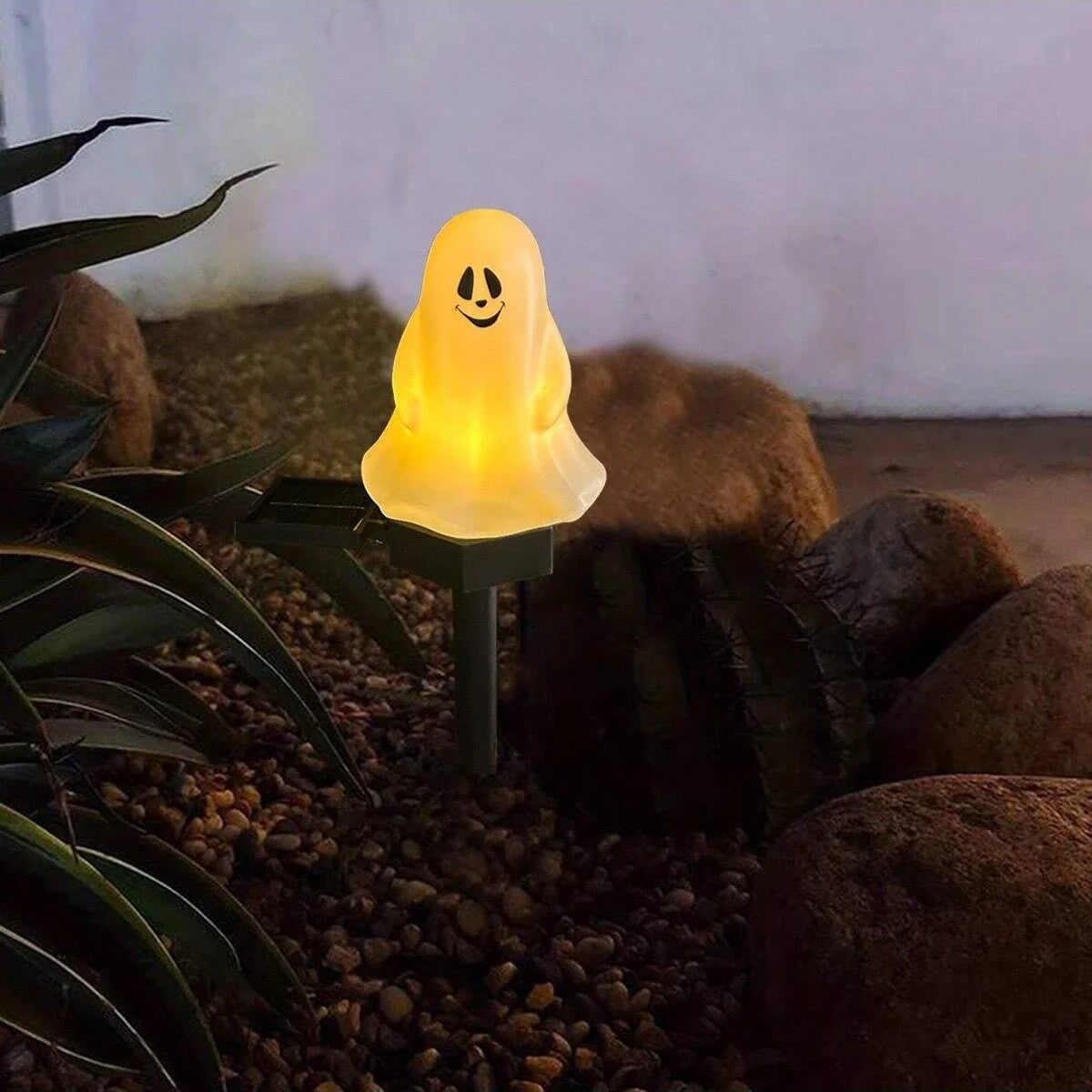 Une lueur fantomatique jaune et brillante dans une piquete, entourée de rochers et de feuillage sombres.
