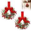 A 10-inch artificial Christmas wreath decorated with green foliage, red berries, and a large red velvet bow.