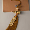 Brass gourd and five emperor coins hanging ornament with a gold tassel on a brown card.
