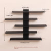 A set of four black floating wall shelves mounted on a light-colored wall.