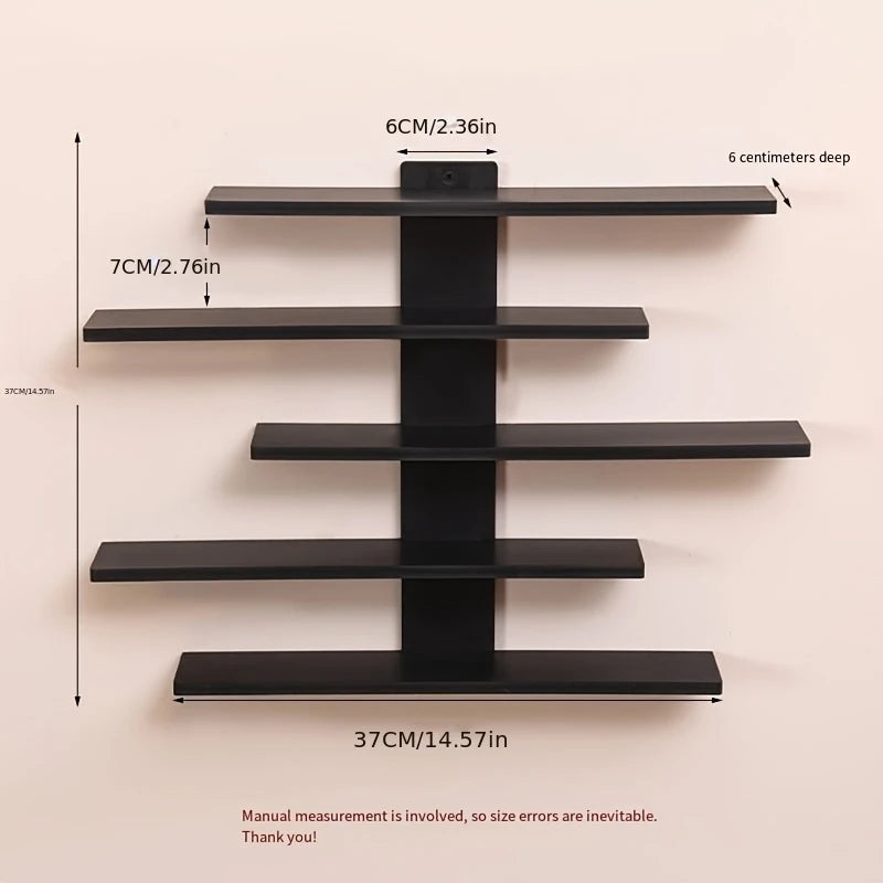 A set of four black floating wall shelves mounted on a light-colored wall.