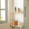 A rustic wooden wall shelf with macrame hangers displaying potted plants and decorative spheres.