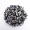 Un amas dense de petites fleurs d'hydrangea artificielles dans des tons de gris et de violet poussiéreux.