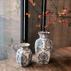 A pair of hand-painted blue and white porcelain vases displayed on a wooden surface.