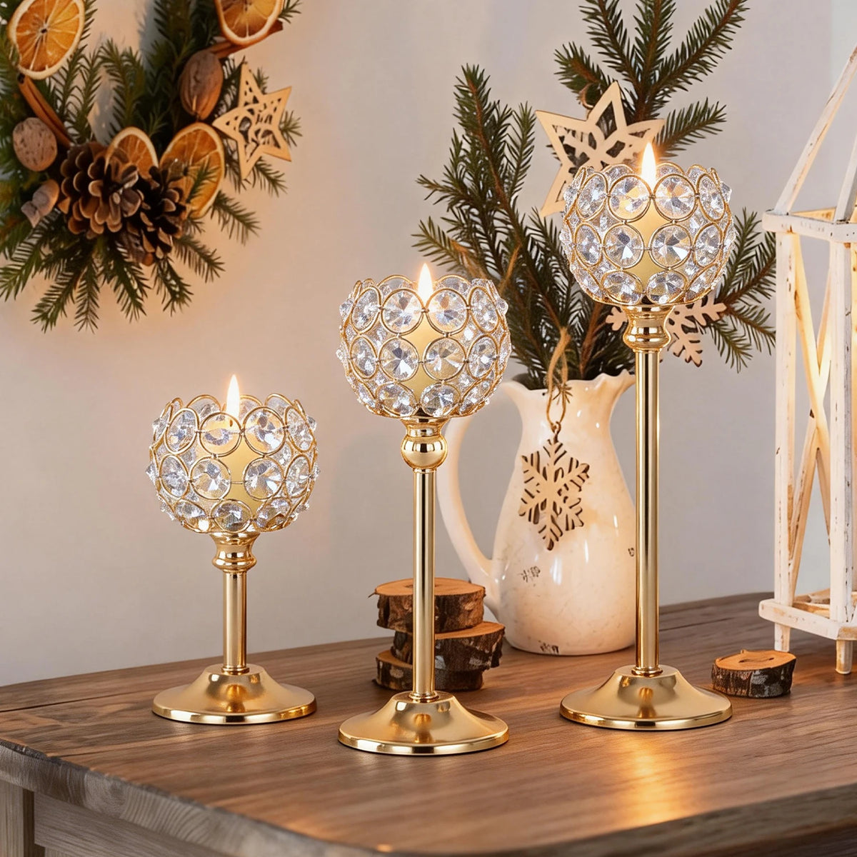 A set of elegant gold metal glass candle holders decorated with pine branches and natural elements.