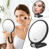 A woman holds a precision dual-magnification handheld mirror, showing both the full mirror and a close-up magnification view.