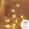 Golden wire frame lights shaped like stars illuminating a glass jar