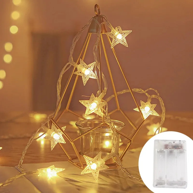 Golden wire frame lights shaped like stars illuminating a glass jar