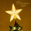 A bright, star-shaped LED glowing Christmas light is displayed on a green fir tree branch against a warm golden background.