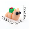 A small, light orange 3D printed cartoon animal figurine with a green ear and red nose.