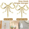 Brass bow hook single hanger in gold color shown with various hanging items