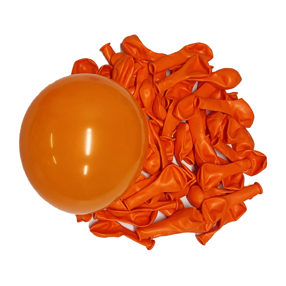 A pile of vibrant orange latex balloons next to a large, inflated orange balloon.