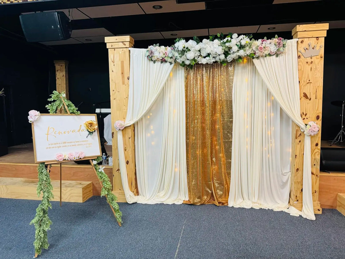 An elegant rectangular backdrop featuring sheer white drapes and gold fringe for an event setting.