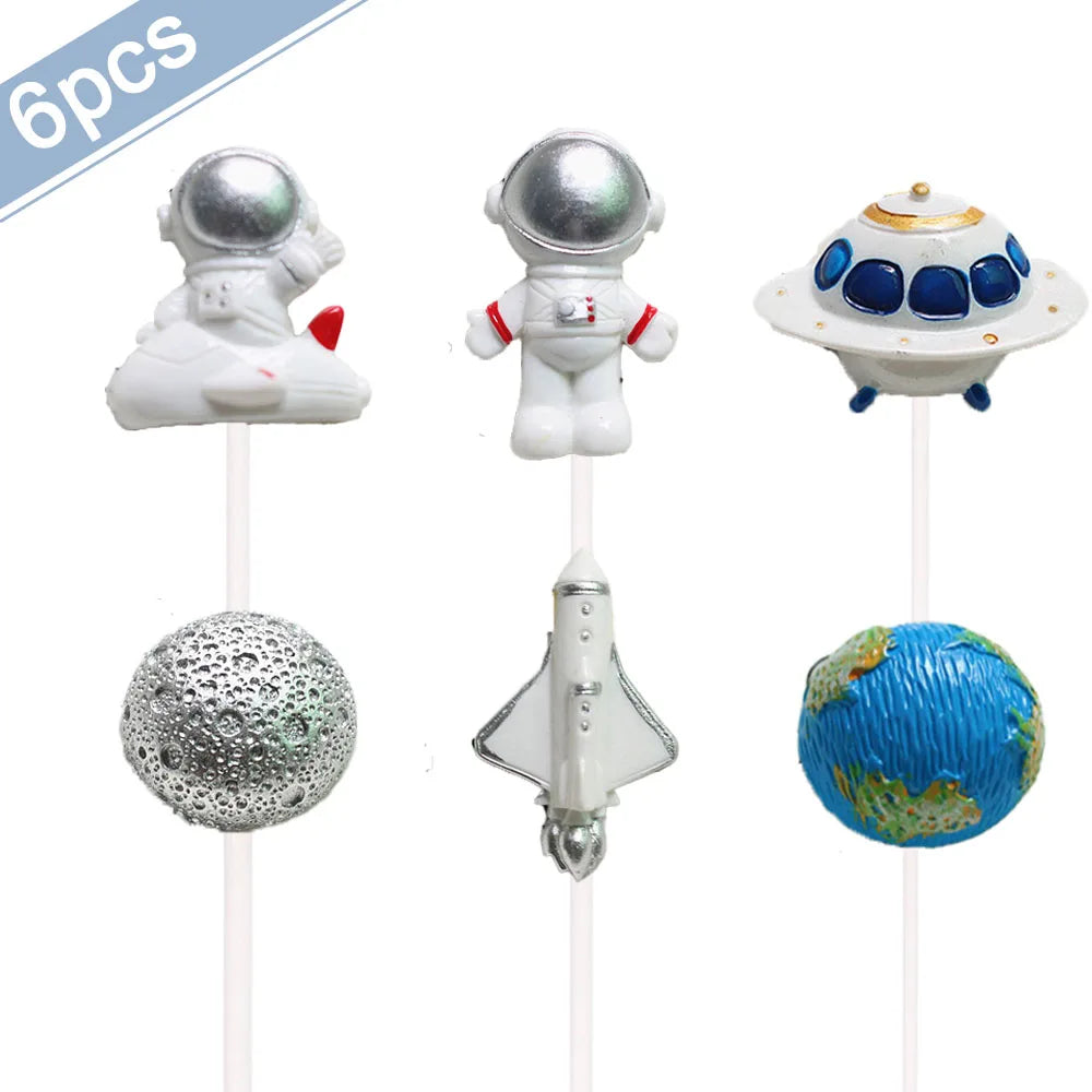 Six décorations de gâteaux d'astronautes miniatures, dont un astronaute blanc, un casque argenté et un globe terrestre bleu.