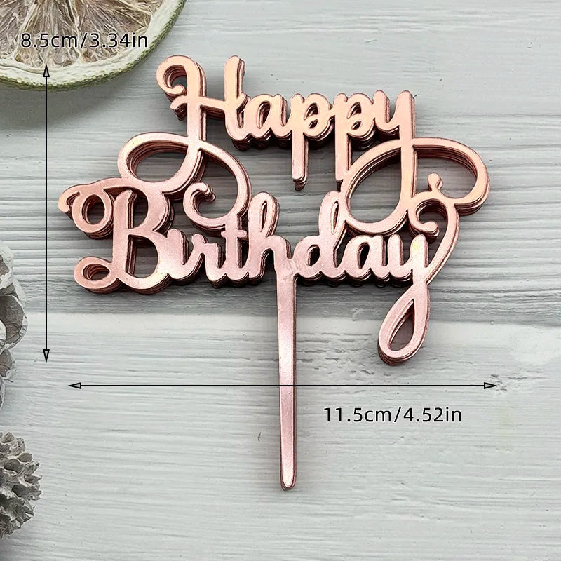A pink and gold acrylic birthday cake topper set with the words Happy Birthday
