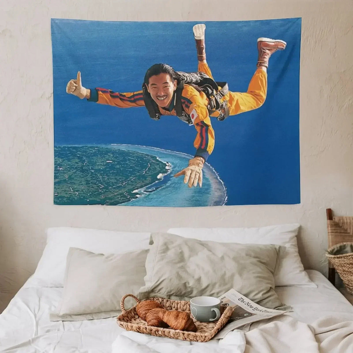 A tapestry featuring a man with long dark hair and yellow clothing making a thumbs-up gesture against a blue ocean background