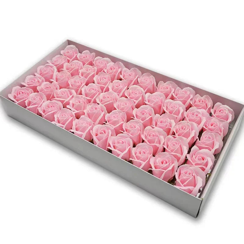 A rectangular box filled with pink artificial rose flower heads for DIY crafts and decor.