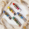 A collection of five natural crystal zodiac wishing bottles filled with raw healing stones displayed on a white background.