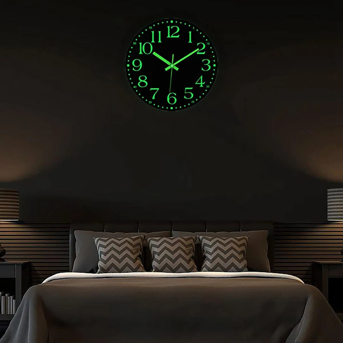 A green glow-in-the-dark wall clock is mounted above a dark bed, showing the time as 12:00.
