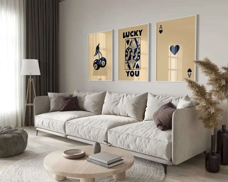 A modern living room features a light sofa, wooden coffee table, and framed art prints on the wall.
