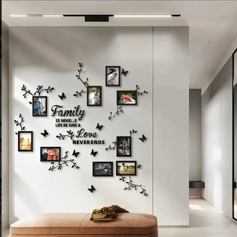 A modern interior wall decorated with black silhouette branches and photo frames featuring family memories.