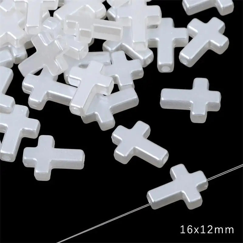 A pile of white acrylic cross shape beads for DIY jewelry making