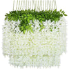 A hanging artificial wisteria flower garland featuring green leaves and white blossoms.