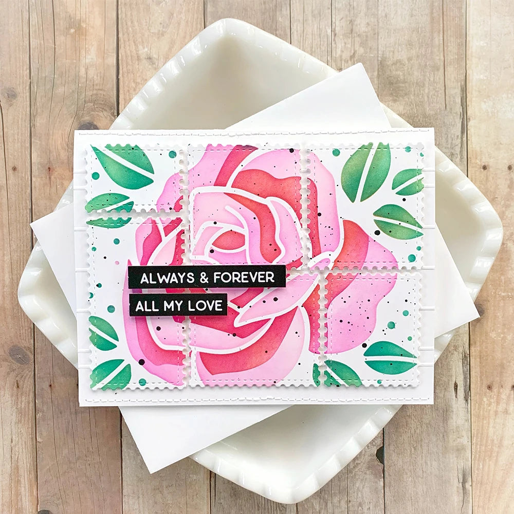 A pink watercolor rose design on a white square stencil and stamp set for DIY scrapbooking