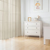 White natural linen sheer curtains with a rod pocket hanging in a bright room.
