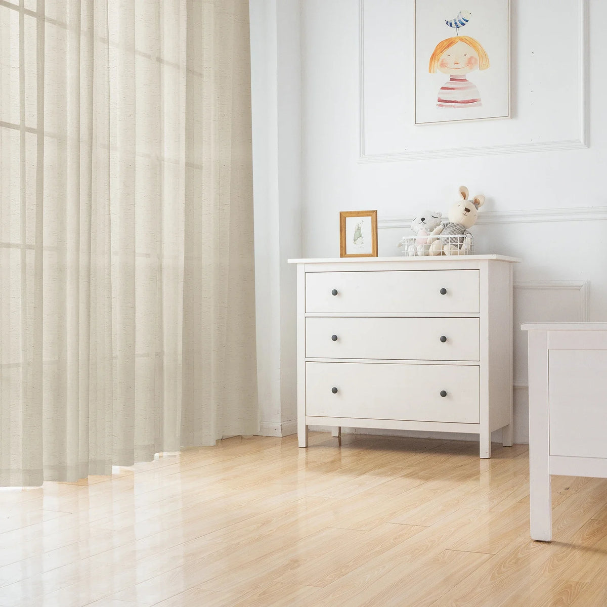 White natural linen sheer curtains with a rod pocket hanging in a bright room.