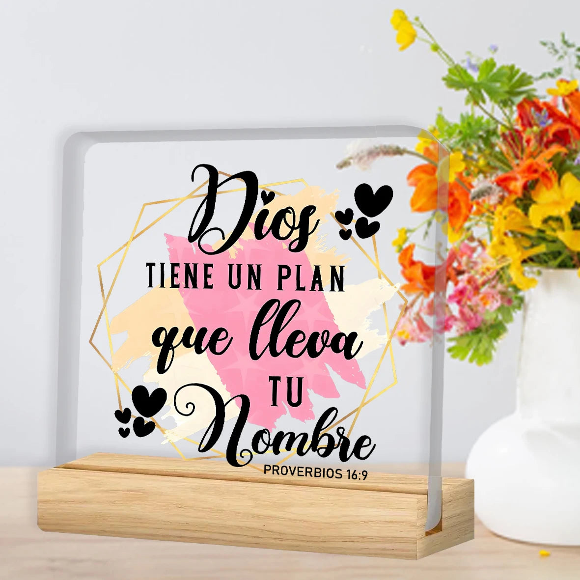 A framed print featuring the text Dios tiene un plan que lleva tu nombre in black script on a light background