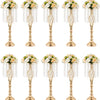 A set of gold crystal vases used for wedding centerpieces, each holding a floral arrangement.