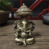 Bronze Ganesha Buddha statue with a dome top sitting on a wooden surface.