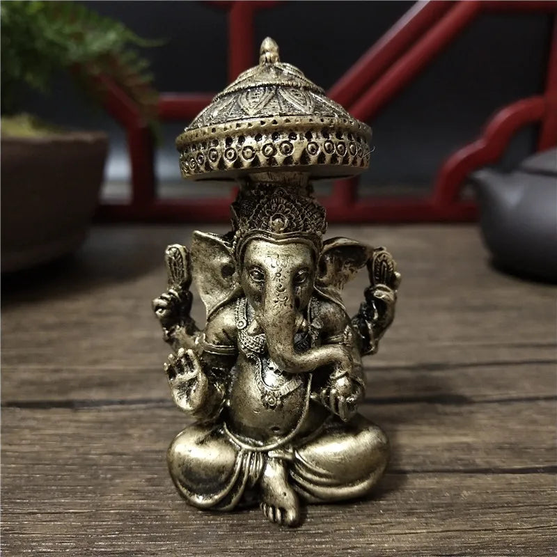 Bronze Ganesha Buddha statue with a dome top sitting on a wooden surface.