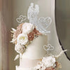 A white wedding cake decorated with roses and a crystal embellished Mr and Mrs topper.