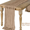 A beige semi-sheer gauze table runner draped over a wooden table.
