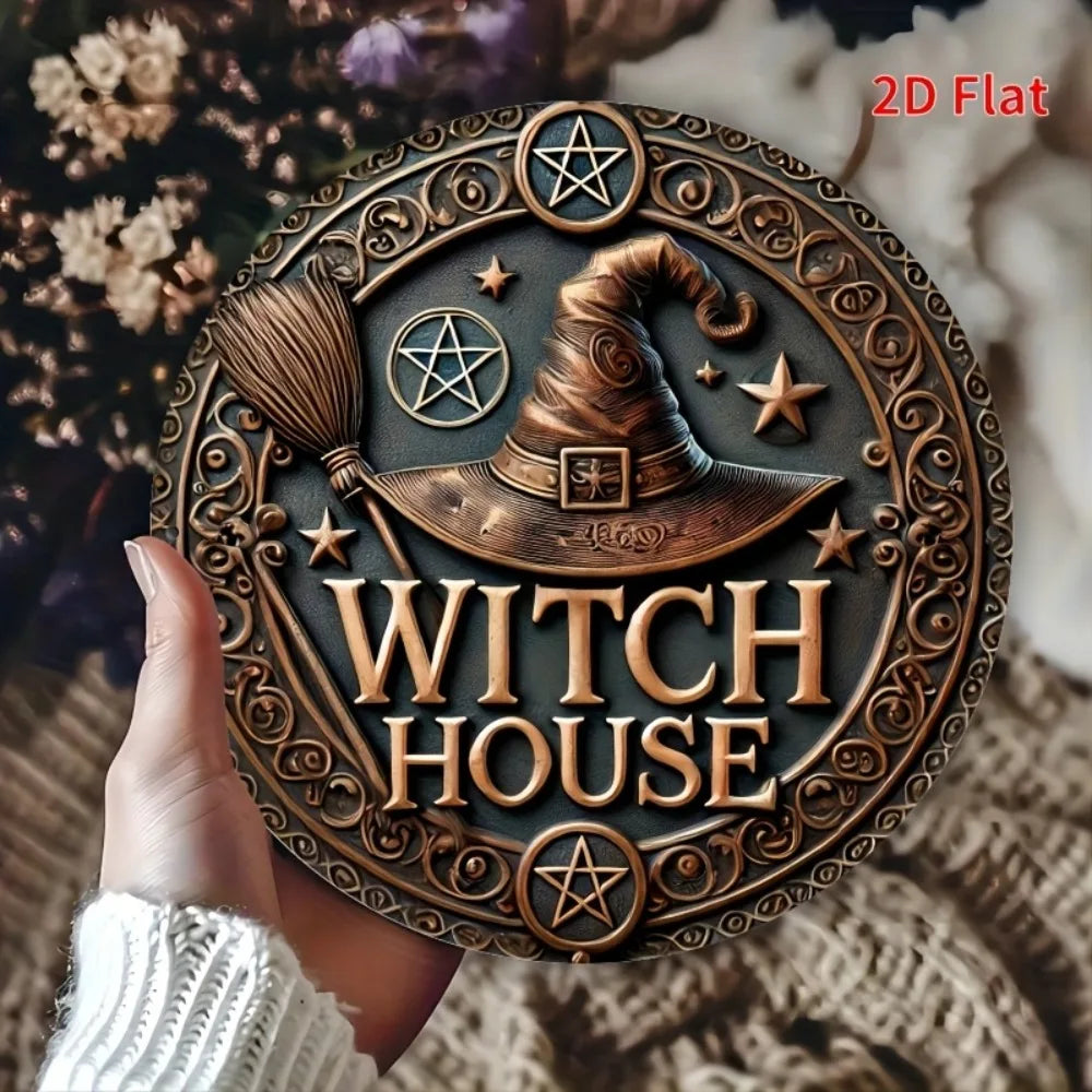 Une main tient un panneau décoratif mural en métal vintage de style maison de sorcière, avec un chapeau de sorcière et une ét