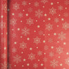 A roll of festive Christmas wrapping paper featuring white snowflakes and gold stars on a red background.