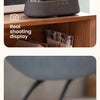 A black wireless charging speaker lamp with a digital display showing time and temperature is placed on a wooden surface.