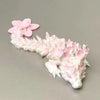 A miniature figurine of a dragon made from pink and white cherry blossoms.