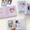 A collection of mini photo card albums and binders featuring K-pop idols, including a pink and blue binder and clear plastic 