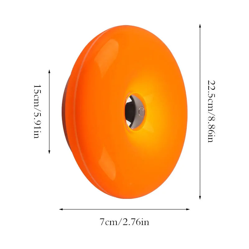 Orange, donutförmige, wiederaufladbare Wandlampe mit glatter, sphärischer Form.