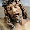 A realistic resin figurine of Jesus with a crown of thorns and long hair, depicting him in a sorrowful expression.