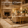A tall, multi-armed gold LED candle holder displayed on a polished marble floor in an elegant interior.
