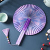 A purple and white traditional Chinese folding fan with a tassel displayed on a dark blue surface.