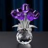 A crystal rose decorative flower arrangement featuring deep purple roses on a silver stem and clear glass base.
